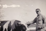 Black and white photo of farmer petting a cow
